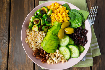 budha bowl with brussel cabbage, corn, quinoa, cucumbers,nuts, avocado and spinach