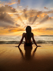 Fototapeta na wymiar Silhouette of a woman on the beach at sunset