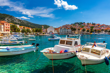 View at amazing archipelago with boats in front of town Hvar, Croatia. Harbor of old Adriatic island town Hvar. Popular touristic destination of Croatia. Amazing Hvar city on Hvar island, Croatia. - obrazy, fototapety, plakaty
