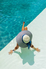 Woman relaxing in swimming pool at spa resort. r