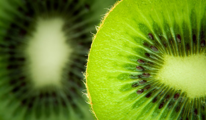 Cross section kiwi close up, with second slice in the background. Macro shot. © Jeroen
