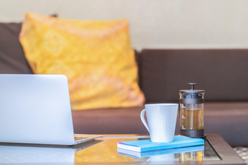 Notebook computers with coffee cups and books on the living room table