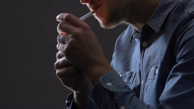 Man lighting cigarette and smoking, nicotine addiction, tobacco poison closeup