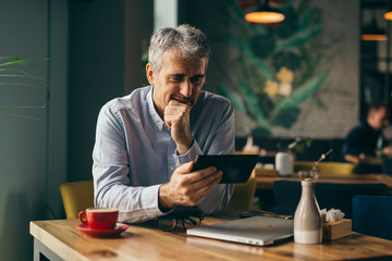 man using tablet in cafe bar.