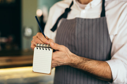 closeup of barman taking an order in notebook