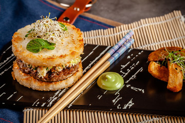 Pan-Asian cuisine concept. Japanese sushi burger made from rice bread, chicken and pork meat...