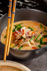 Pan-Asian cuisine concept. Japanese miso soup Tom Yam Kung with seafood, shrimps, mussels, calamari. Serving dishes in the restaurant in the bowl. Background image.