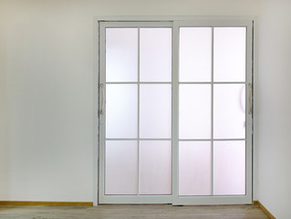 Sliding door with transparent glass in empty room.
