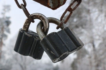 two old iron locks on  thick steel rusty chain