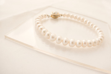 Pearl bracelet on a reflective surface