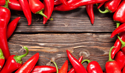 Red hot chili peppers on wood background