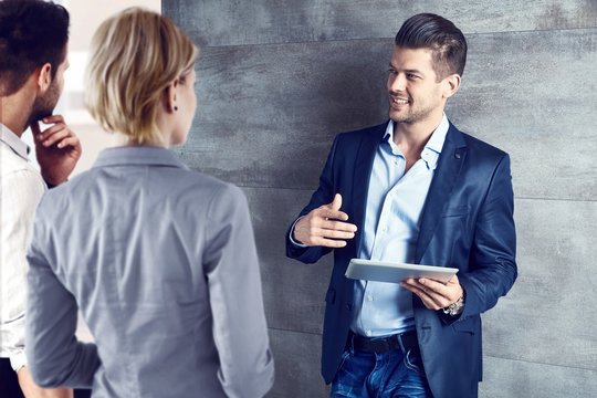 Business People Talking At Office Using Tablet