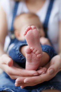 Baby feet in mother hands.Tiny Newborn Baby's feet on female  hands closeup.Beautiful conceptual image of Maternity Happy Mom with Infant. Baby feet on mother's palms.Close up of newborn baby feet.