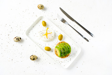 Healthy food concept: toast with avocado, green olives and poached egg