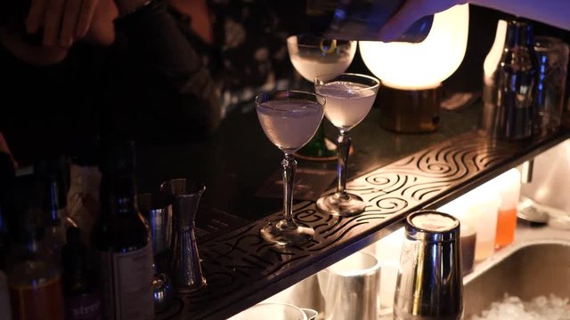 Two lemon drop cocktails poured out at a trendy bar with a great atmosphere