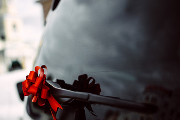 Fototapeta premium black car door handle decorated with red bow