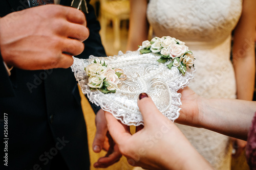 wedding rings on a heart-shaped pillow