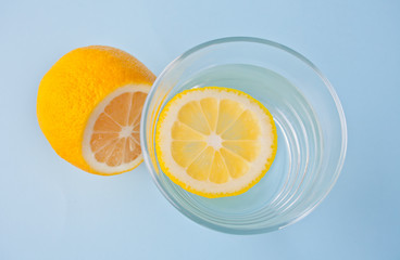 water with lemon on the blue background. Top view.