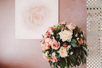 bouquet of yellow and pink flowers against the background of the image of a rose on a pink wall