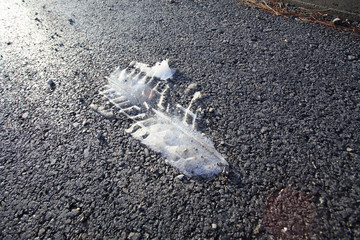 Snow trail of the car on the asphalt