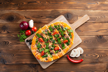 pizza with veal and dried tomatoes on a wooden background