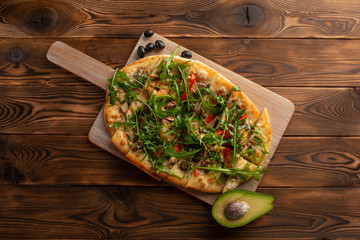 pizza with seafood and arugula on a wooden background
