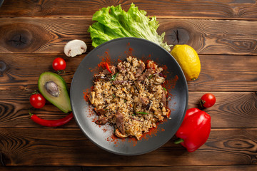 spicy fried rice with lamb in black plate on wooden background
