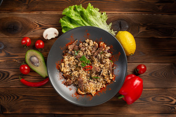 spicy fried rice with lamb in black plate on wooden background