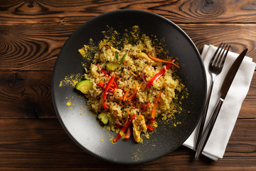 jasmine rice with curry chicken in a black plate on wooden background