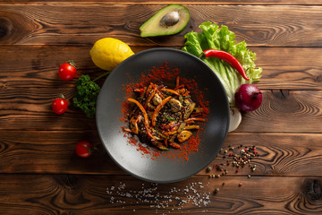 wok vegetables in a black plate on a wooden background