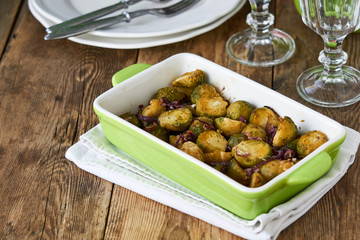 Baked brussels sprouts with red onions in ceramic form   