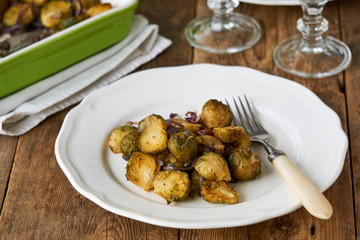 Baked brussels sprouts with red onions on a white plate