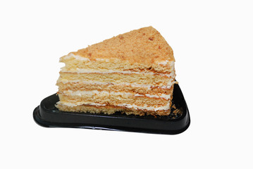 Honey cake with cream on the black plastic disposal stand