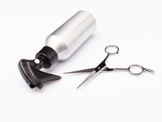 White  metallic hairdresser spray bottle and professional stainless steel scissors.