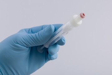 Medizinerhand h&auml;lt Serumkan&uuml;le f&uuml;r eine Blutentnahme