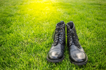 male black shoes over green meadow in a park