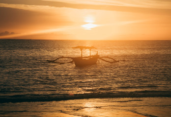 Fototapeta na wymiar beautiful sunset on tropical beach by the sea in Bali