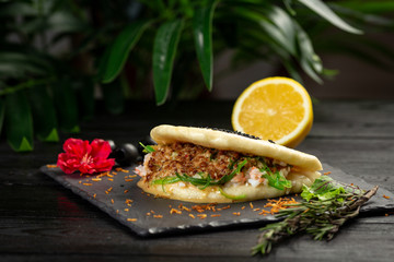 bao with lamb on a black plate on a wooden background