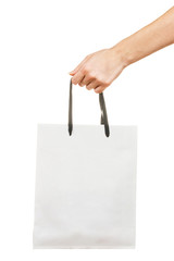 Female hand holding white paper shopping bag isolated on white background. Delivery concept