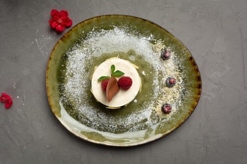 milk dessert with fruit and chocolate on a green plate