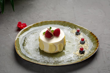 milk dessert with fruit and chocolate on a green plate