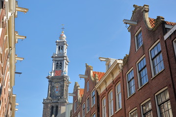 Crooked and colorful heritage buildings, located along Bloemstraat street, with Westerkerk church clocktower in the background, Jordaan, Amsterdam, Netherlands