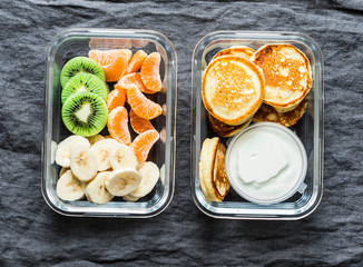 Healthy kids school, walk, picnic lunch box - pancakes with sour cream and banana, kiwi, tangerine...