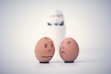 Two broken dark eggs employee in the form of human head complain to each other. Boss egg on the background.