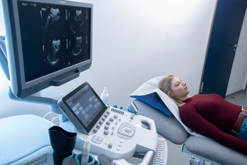 Patientin auf Untersuchungsliege wartet auf Radiologen in der Sonographie