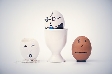 Angry boss and two employees in the form of white and dark eggs.  Creative. Concept