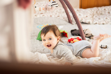 Fototapeta premium happy baby smiling while playing in bed