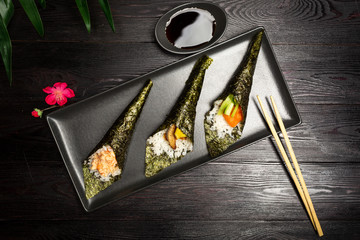 Temaki mix with salmon, eel and shrimp on a dark wooden background
