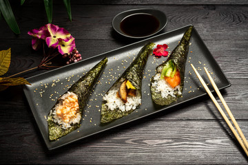 Temaki mix with salmon, eel and shrimp on a dark wooden background