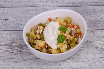 Traditional Russian salad with chicken in the white bowl